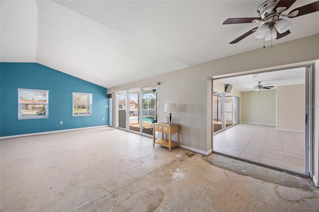 spare room featuring vaulted ceiling, a textured ceiling, and ceiling fan