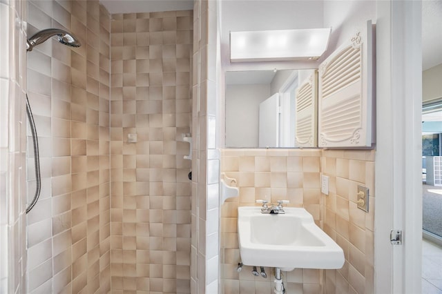 bathroom featuring tile walls, sink, and tiled shower