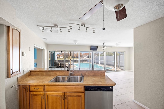 kitchen with stainless steel dishwasher, sink, and a textured ceiling