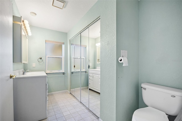 bathroom with vanity, toilet, and tile patterned floors