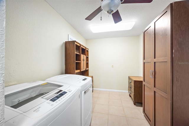 clothes washing area featuring washing machine and dryer, light tile patterned flooring, a textured ceiling, ceiling fan, and cabinets