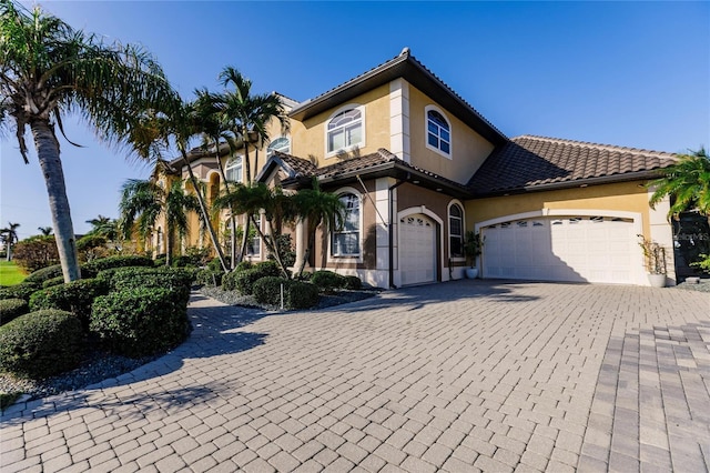 1209 San Mateo Dr, Punta Gorda, FL 33950 - mediterranean / spanish home featuring a garage, stucco siding, decorative driveway, and a tile roof
