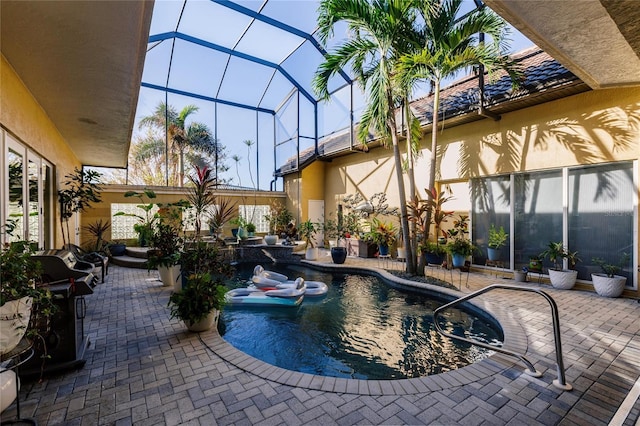 view of pool featuring a patio, grilling area, and glass enclosure