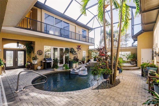 view of swimming pool featuring french doors, a patio, a lanai, and a grill