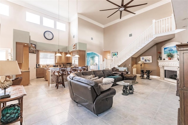 living room featuring crown molding, light tile patterned flooring, a high ceiling, and ceiling fan