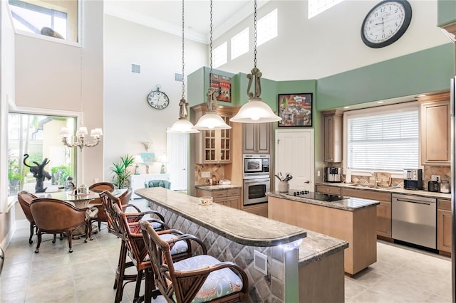 kitchen featuring stainless steel appliances, hanging light fixtures, a wealth of natural light, and a kitchen island