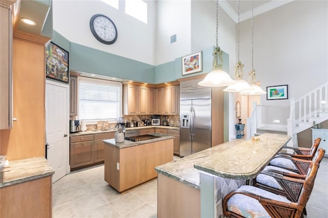 1209 San Mateo Dr, Punta Gorda, FL 33950 - kitchen featuring stainless steel built in refrigerator, a kitchen island, a towering ceiling, backsplash, and crown molding