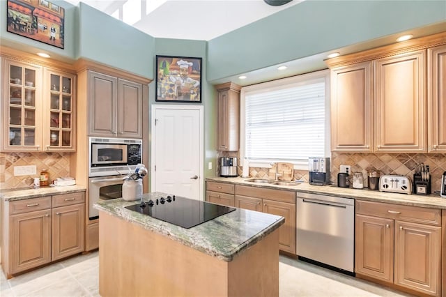 kitchen with sink, a center island, appliances with stainless steel finishes, and tasteful backsplash