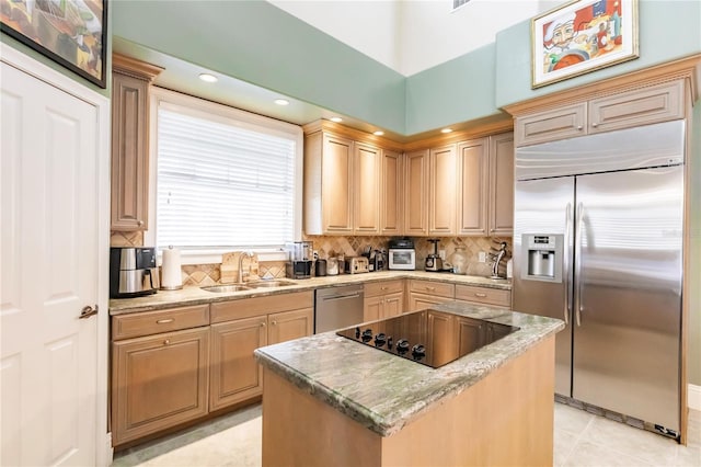 kitchen with light brown cabinetry, sink, a kitchen island, stainless steel appliances, and decorative backsplash