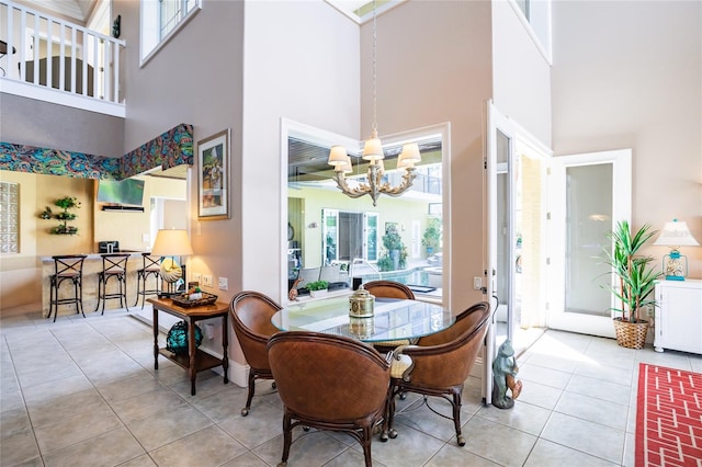 tiled dining area with a notable chandelier and a high ceiling