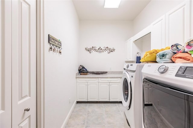 laundry area with cabinets, washing machine and clothes dryer, and light tile patterned floors