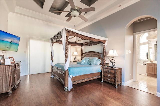 bedroom featuring hardwood / wood-style flooring, beamed ceiling, ensuite bath, ornamental molding, and ceiling fan