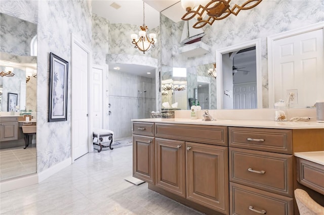 bathroom with walk in shower, a high ceiling, ceiling fan with notable chandelier, vanity, and tile patterned floors