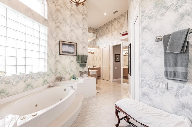 bathroom featuring vanity, a tub, and a healthy amount of sunlight