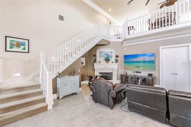 tiled living room featuring crown molding and a high ceiling