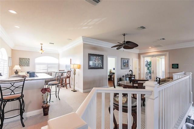 carpeted living room featuring ceiling fan and ornamental molding