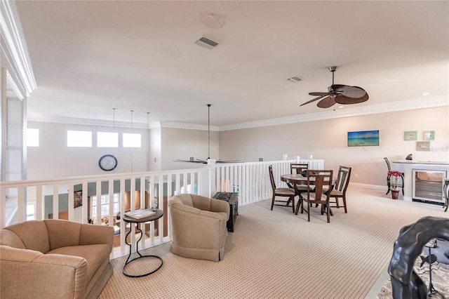 carpeted living room featuring crown molding and ceiling fan