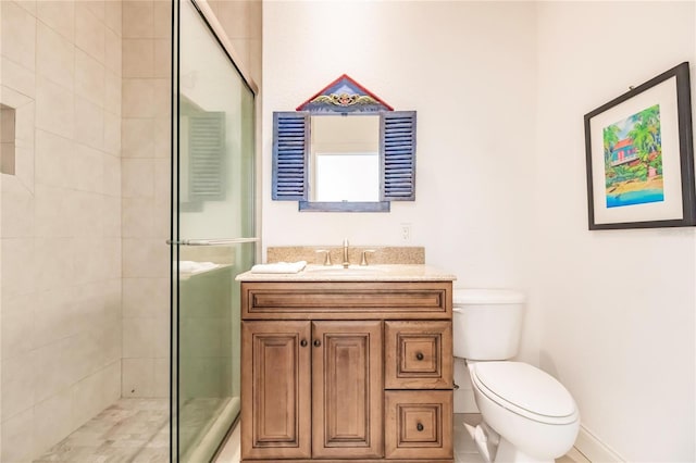 bathroom with toilet, a shower with shower door, and vanity