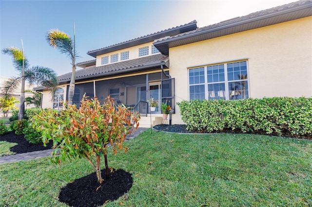 1209 San Mateo Dr, Punta Gorda, FL 33950 - rear view of house with a sunroom, a lawn, ceiling fan, and stucco siding
