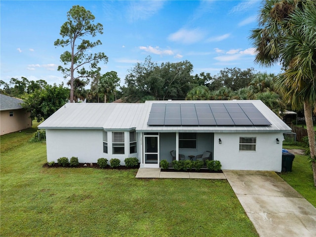 ranch-style home with a front lawn and solar panels