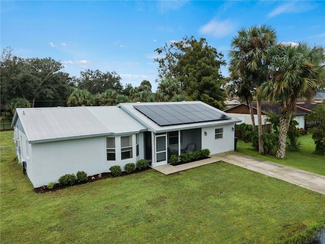 single story home with solar panels and a front lawn