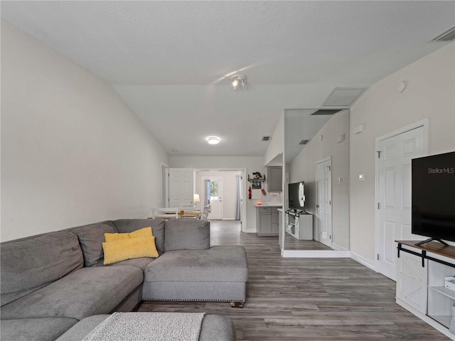 living room featuring lofted ceiling and dark hardwood / wood-style floors