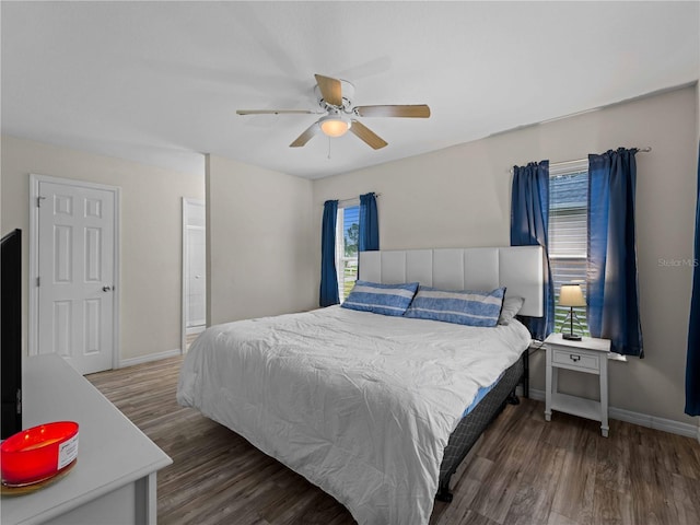 bedroom featuring multiple windows, ceiling fan, and dark hardwood / wood-style floors