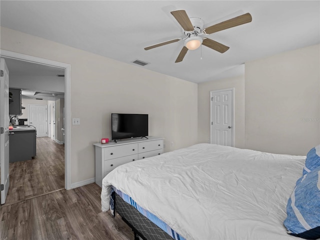 bedroom with dark hardwood / wood-style floors and ceiling fan