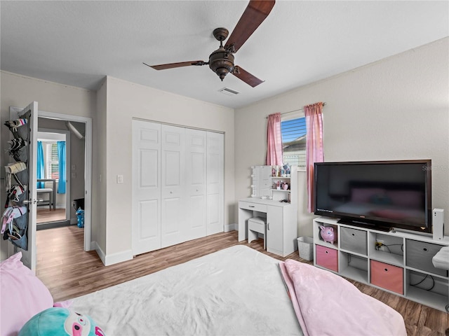 bedroom featuring ceiling fan, a closet, and wood-type flooring