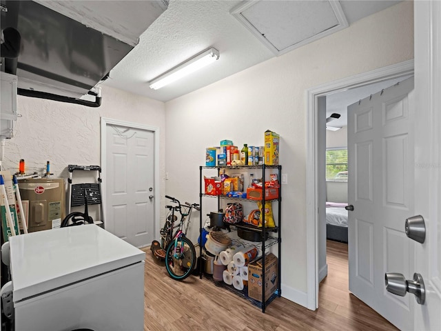 miscellaneous room with a textured ceiling, hardwood / wood-style floors, and water heater