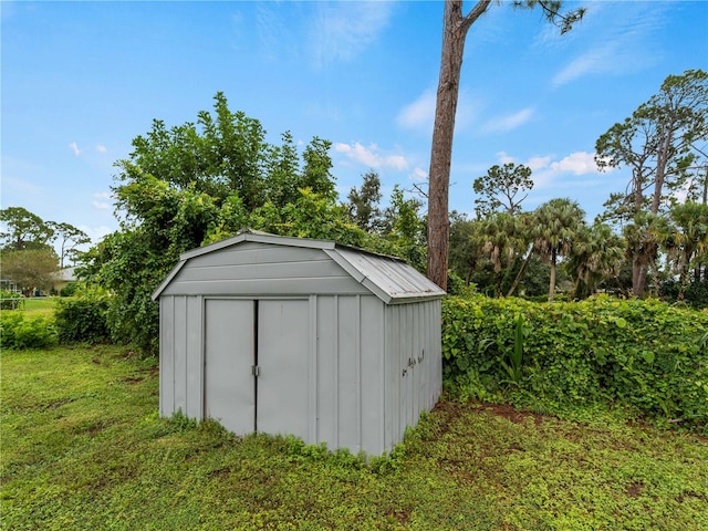 view of outbuilding with a yard