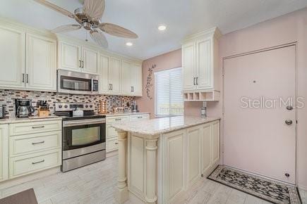 9011 Midnight Pass Rd Unit 329, Sarasota, FL 34242 - kitchen featuring stainless steel appliances, light countertops, decorative backsplash, ceiling fan, and a peninsula
