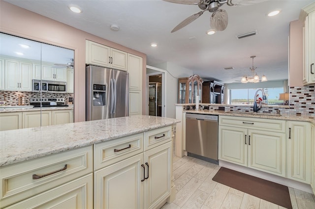 9011 Midnight Pass Rd Unit 329, Sarasota, FL 34242 - kitchen featuring appliances with stainless steel finishes, cream cabinets, a ceiling fan, tasteful backsplash, and recessed lighting