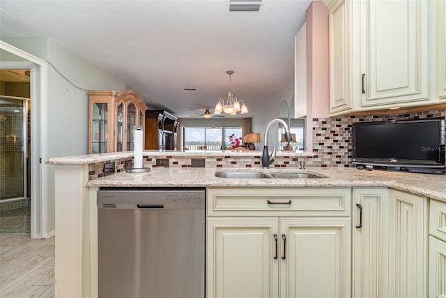 9011 Midnight Pass Rd Unit 329, Sarasota, FL 34242 - kitchen with stainless steel dishwasher, cream cabinetry, a chandelier, decorative backsplash, and light stone counters