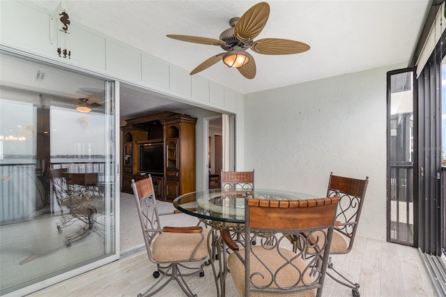 9011 Midnight Pass Rd Unit 329, Sarasota, FL 34242 - dining area featuring light wood finished floors, a textured wall, and ceiling fan