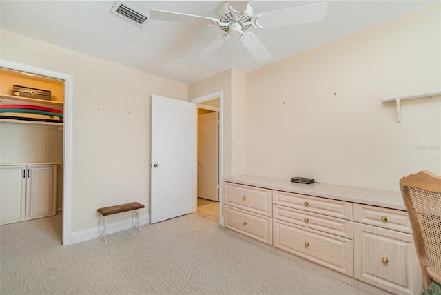 unfurnished bedroom with a closet, light colored carpet, and ceiling fan