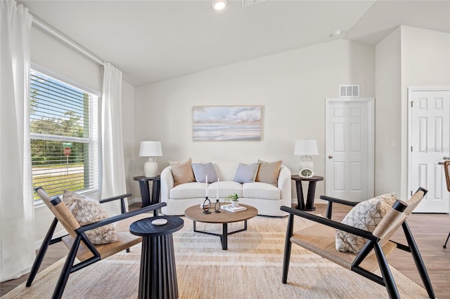 living room with light hardwood / wood-style flooring and lofted ceiling