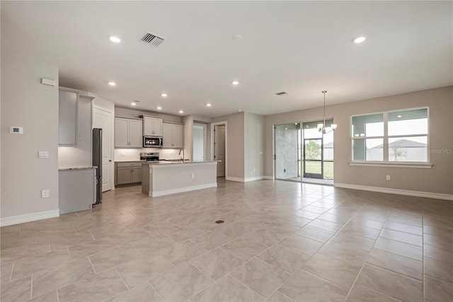 unfurnished living room with sink and a chandelier