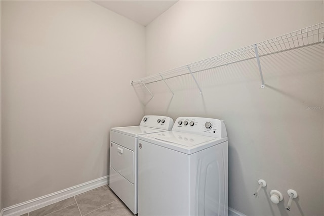 clothes washing area with washer and clothes dryer and light tile patterned flooring