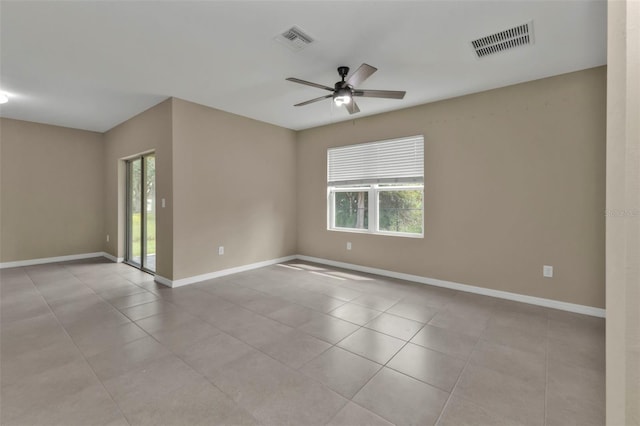 tiled empty room featuring ceiling fan