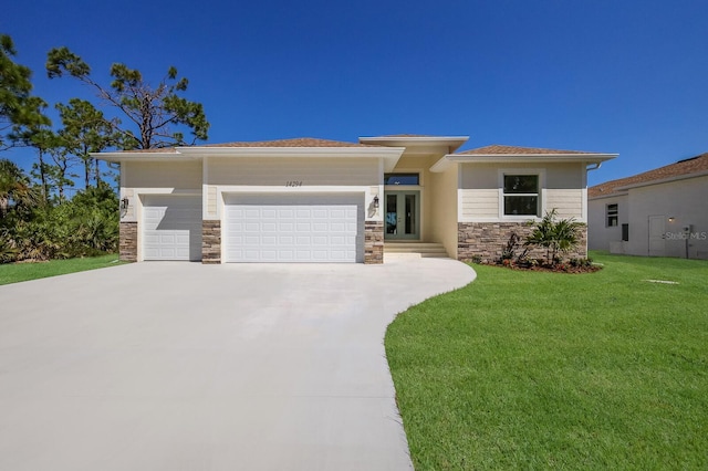 prairie-style home with a front yard and a garage