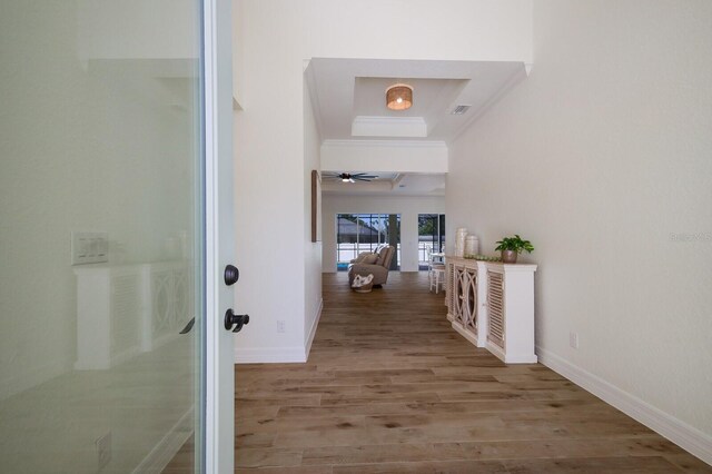 14294 Mcfarland Ave, Port Charlotte, FL 33981 - hall featuring visible vents, a raised ceiling, baseboards, ornamental molding, and wood finished floors