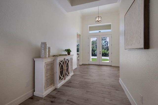 14294 Mcfarland Ave, Port Charlotte, FL 33981 - entryway featuring wood finished floors, baseboards, french doors, crown molding, and a towering ceiling