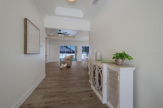 14294 Mcfarland Ave, Port Charlotte, FL 33981 - corridor with visible vents, a raised ceiling, baseboards, ornamental molding, and wood finished floors