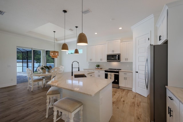 14294 Mcfarland Ave, Port Charlotte, FL 33981 - kitchen with a sink, stainless steel appliances, light wood-style floors, backsplash, and white cabinets