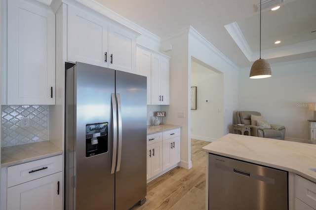 14294 Mcfarland Ave, Port Charlotte, FL 33981 - kitchen with decorative backsplash, crown molding, white cabinets, stainless steel appliances, and light wood finished floors
