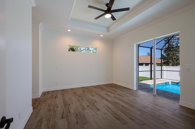 14294 Mcfarland Ave, Port Charlotte, FL 33981 - unfurnished room featuring wood finished floors, a ceiling fan, a tray ceiling, and crown molding