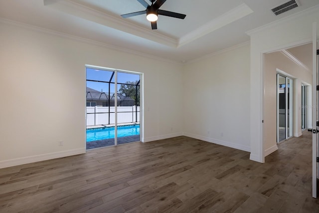 unfurnished room featuring crown molding, hardwood / wood-style floors, ceiling fan, and a raised ceiling