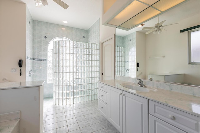 bathroom featuring a tile shower, vanity, tile patterned floors, and ceiling fan