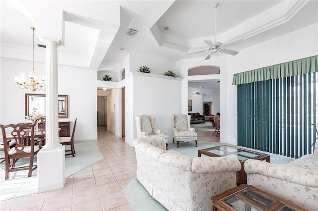 living room featuring decorative columns, light tile patterned floors, a raised ceiling, ceiling fan with notable chandelier, and a high ceiling